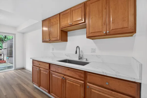 a kitchen with stainless steel appliances granite countertop a sink and cabinets with wooden floor