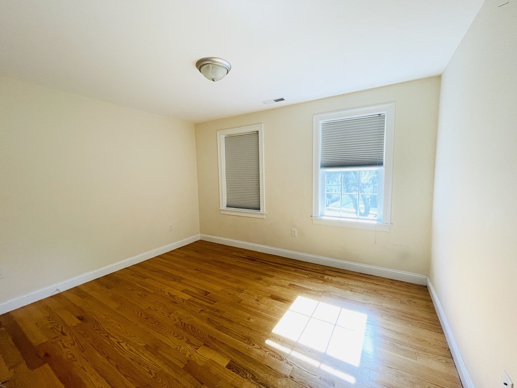 127 Lowell Street Lexington, MA 02420 - Photo 17 of 33 an empty room with wooden floor and windows