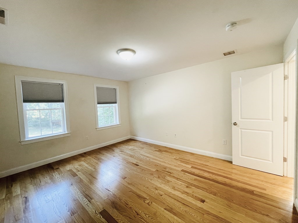 127 Lowell Street Lexington, MA 02420 - Photo 21 of 33 a view of an empty room with wooden floor and a window