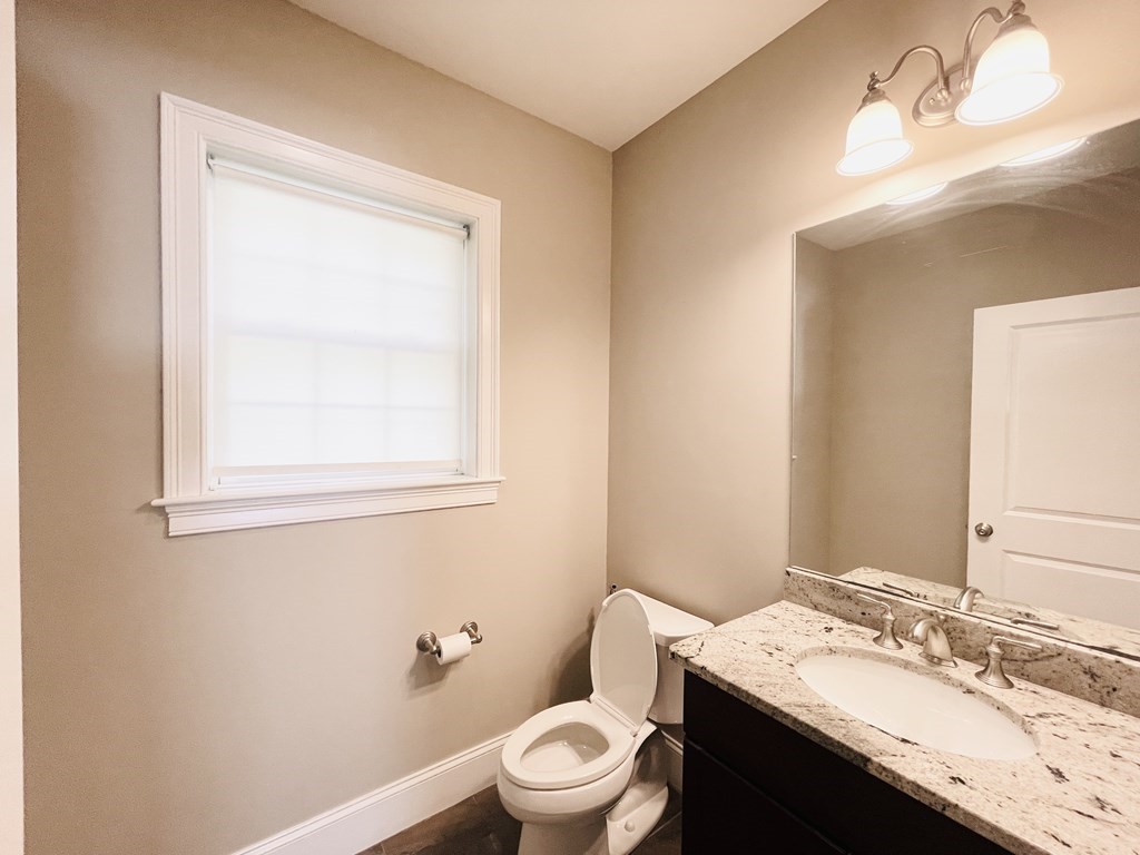 127 Lowell Street Lexington, MA 02420 - Photo 10 of 33 a bathroom with a granite countertop sink toilet a mirror and a window