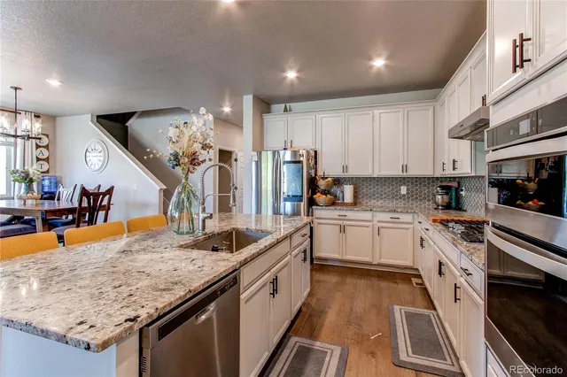 a kitchen with stainless steel appliances granite countertop a sink stove and refrigerator