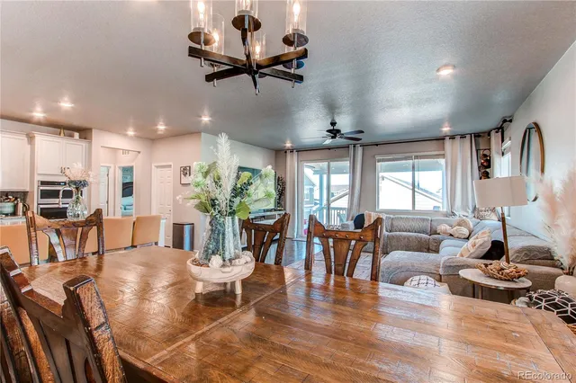a living room with furniture kitchen view and a large window