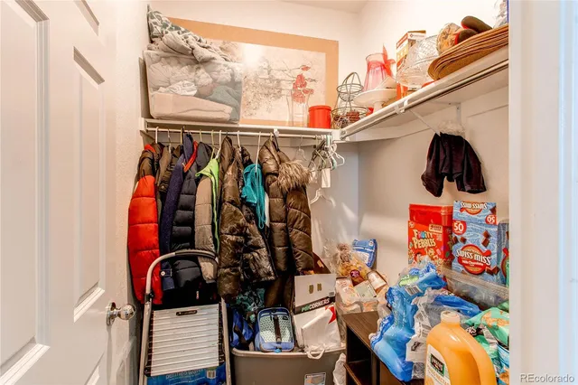 a view of walk in closet with clothes and shoes