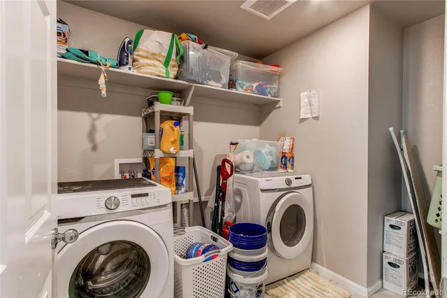 a utility room with dryer washer and a view of living room