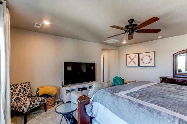 a bedroom with furniture and a flat screen tv