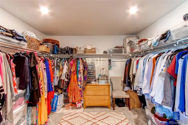 a view of walk in closet with clothes