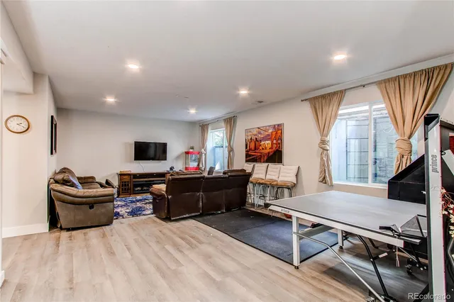 a living room with furniture a flat screen tv and a large window