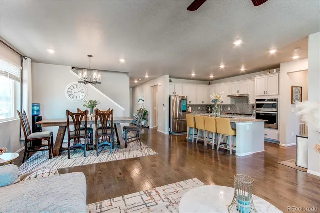 a open kitchen view with stainless steel appliances refrigerator dining table and chairs