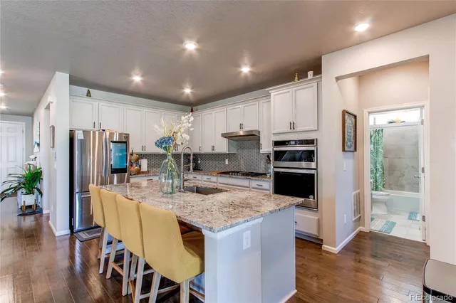 a kitchen with kitchen island a refrigerator stove microwave and cabinets