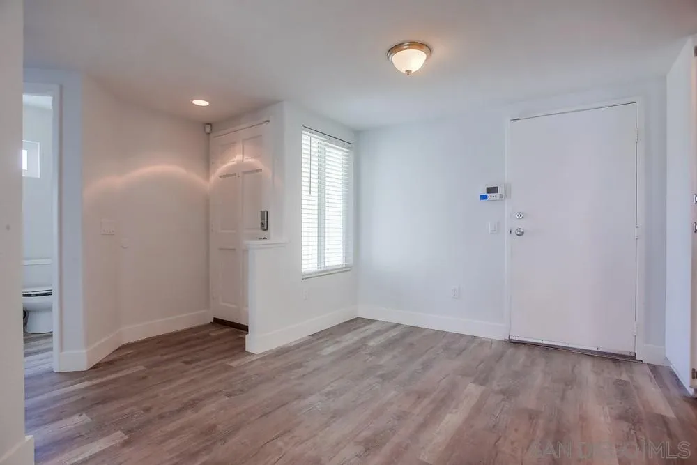 450 Stoney Point Way, Unit 135 Oceanside, CA 92058 - Photo 12 of 38 an empty room with wooden floor and windows