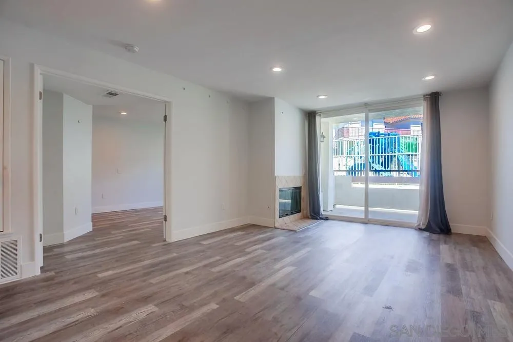 450 Stoney Point Way, Unit 135 Oceanside, CA 92058 - Photo 14 of 38 a view of an empty room with wooden floor and a window