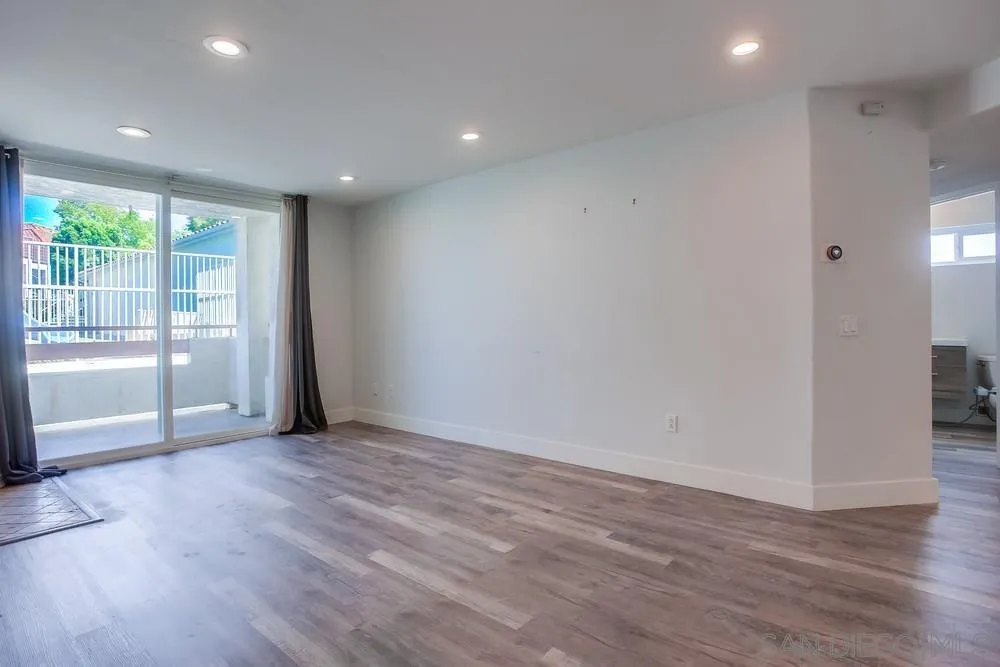 450 Stoney Point Way, Unit 135 Oceanside, CA 92058 - Photo 15 of 38 a view of an empty room with wooden floor and a window