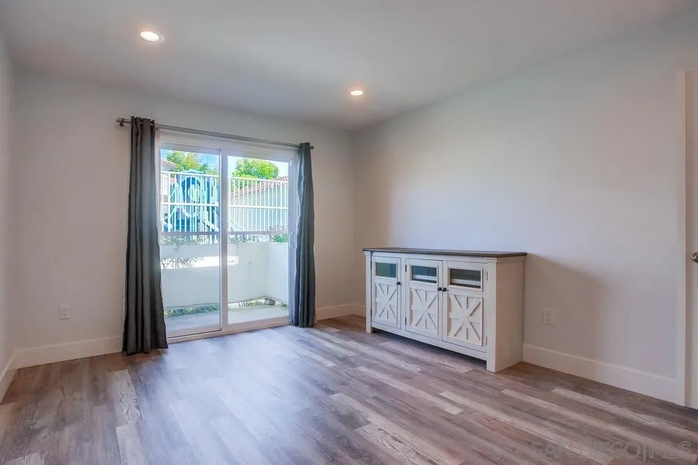 450 Stoney Point Way, Unit 135 Oceanside, CA 92058 - Photo 17 of 38 an empty room with wooden floor and window