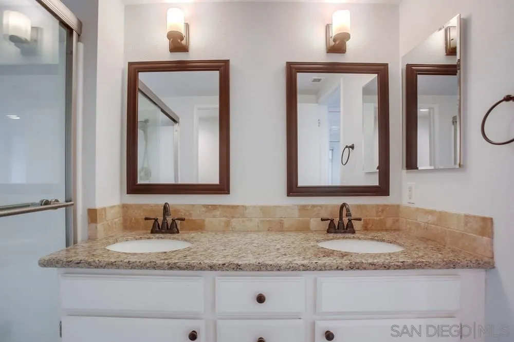 450 Stoney Point Way, Unit 135 Oceanside, CA 92058 - Photo 22 of 38 a bathroom with double vanity sinks granite and a mirror
