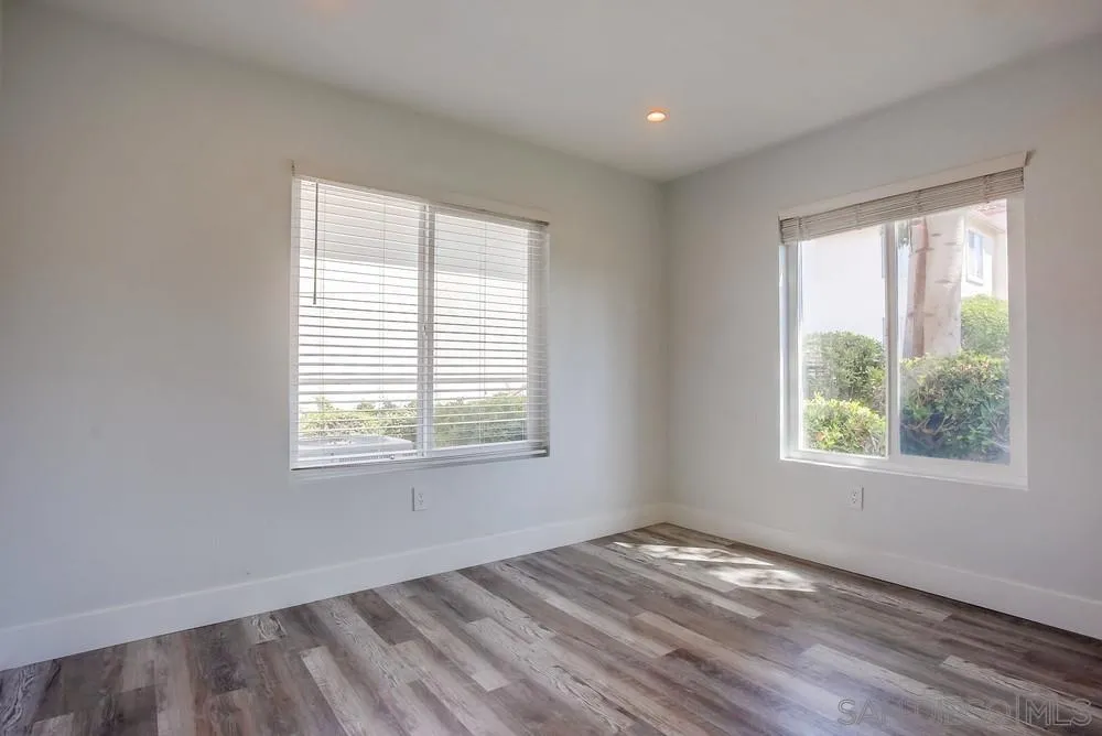 450 Stoney Point Way, Unit 135 Oceanside, CA 92058 - Photo 24 of 38 a view of an empty room with wooden floor and a window