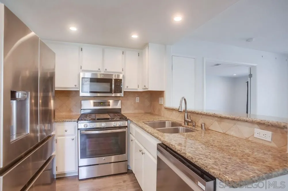 450 Stoney Point Way, Unit 135 Oceanside, CA 92058 - Photo 8 of 38 a kitchen with stainless steel appliances granite countertop a sink stove and refrigerator