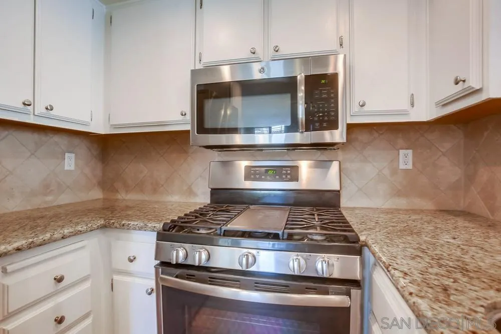 450 Stoney Point Way, Unit 135 Oceanside, CA 92058 - Photo 9 of 38 a stove top oven sitting inside of a kitchen