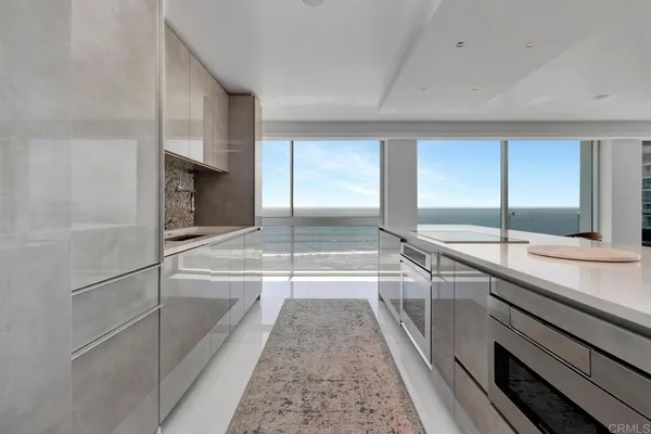 a kitchen with a sink a stove and chairs