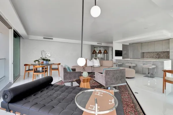 a living room with furniture a rug and white walls