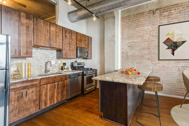 a kitchen with granite countertop a sink stove and cabinets