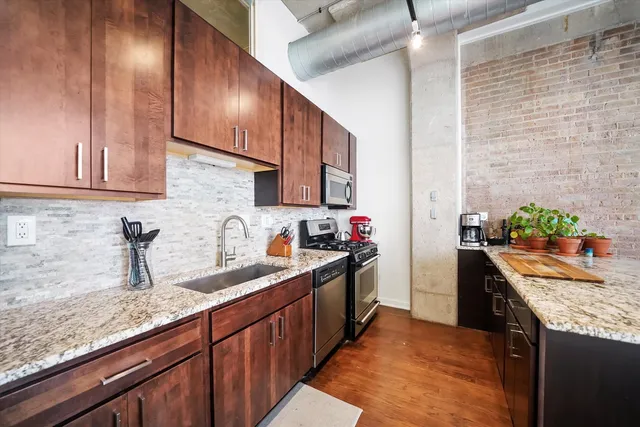 a kitchen with granite countertop a sink stove and cabinets