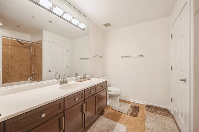 a spacious bathroom with a double vanity sink toilet and a mirror
