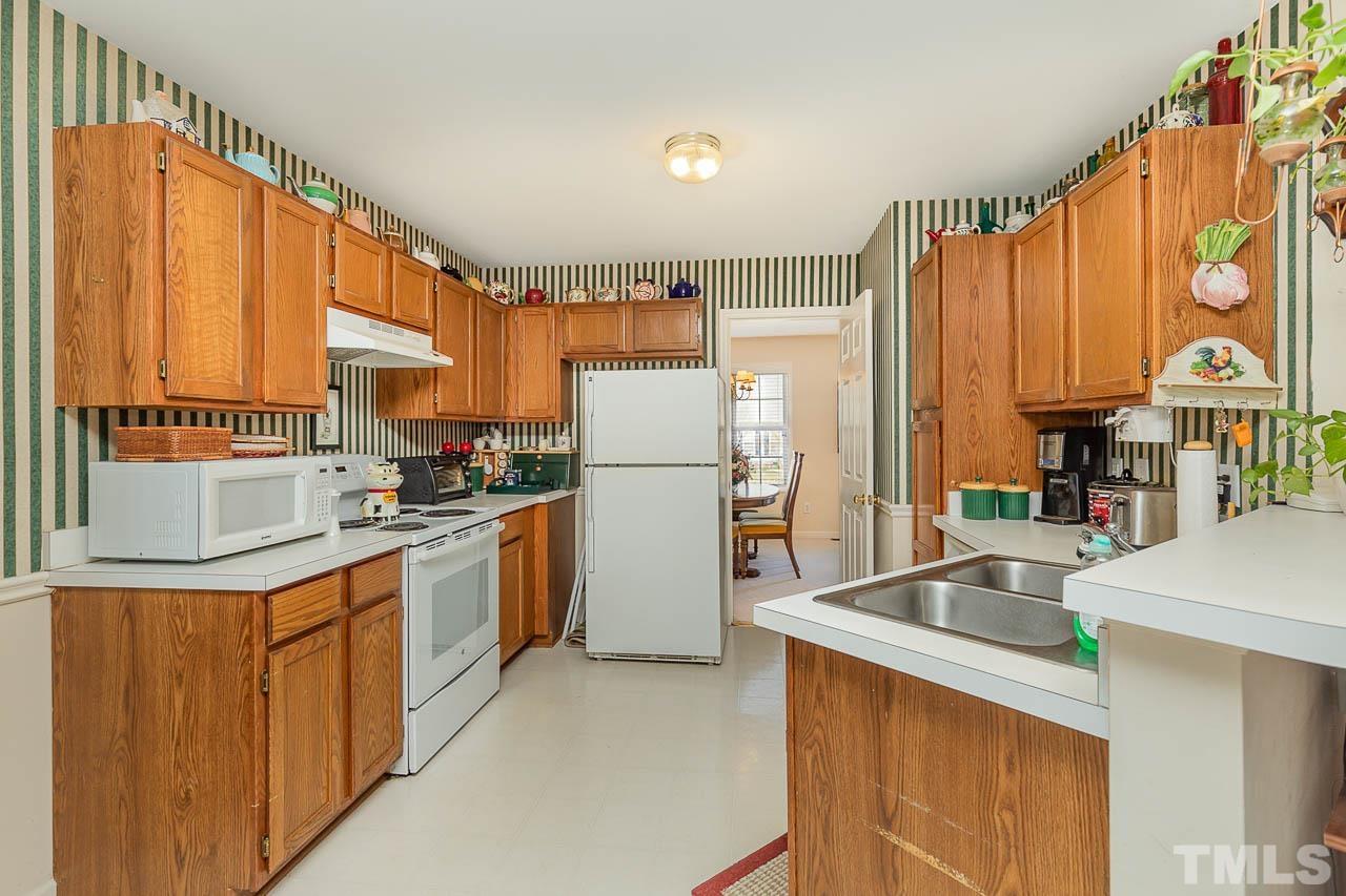 4412 Emmit Drive Raleigh, NC 27604 - Photo 15 of 22 a kitchen with stainless steel appliances a large window and a refrigerator