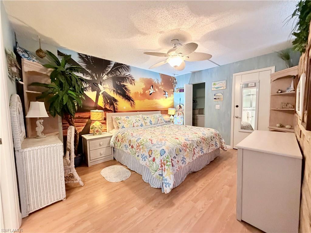 5800 Bonita Beach Road Southwest, Unit 2805 Bonita Springs, FL 34134 - Photo 12 of 30 Bedroom featuring a textured ceiling, light wood finished floors, and ceiling fan