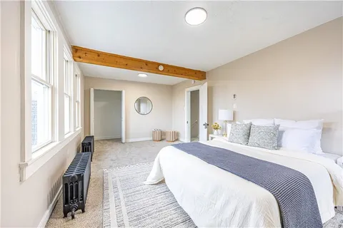 a bedroom with a bed and a large window with outer view