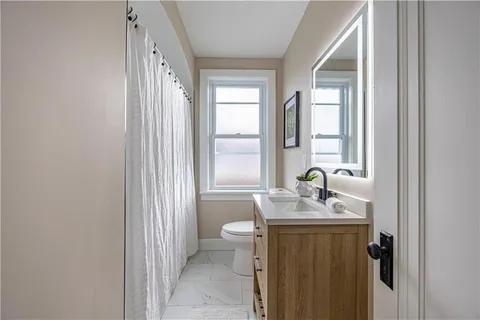 a bathroom with a granite countertop sink a toilet and a mirror