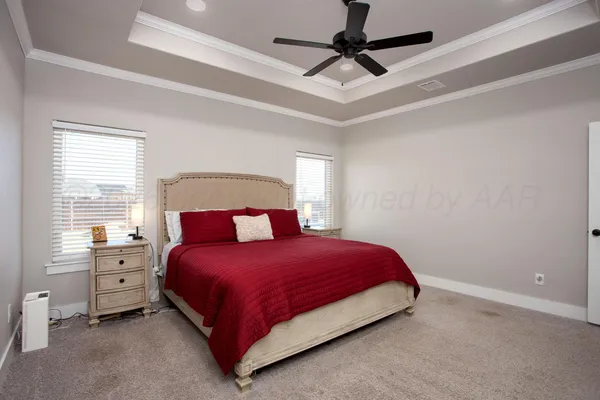 a bedroom with a bed chandelier and a window
