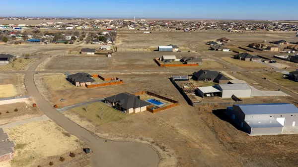 an aerial view of a house with a mountain
