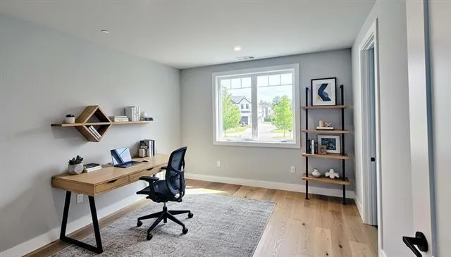 a view of a workspace with furniture and a window