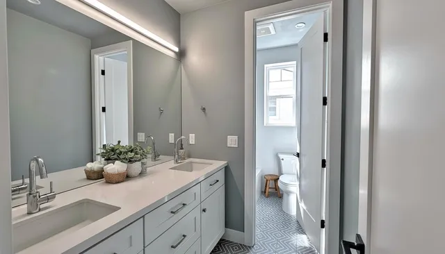a bathroom with a double vanity sink and a mirror