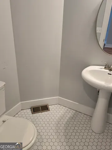 a bathroom with a sink a toilet and a mirror