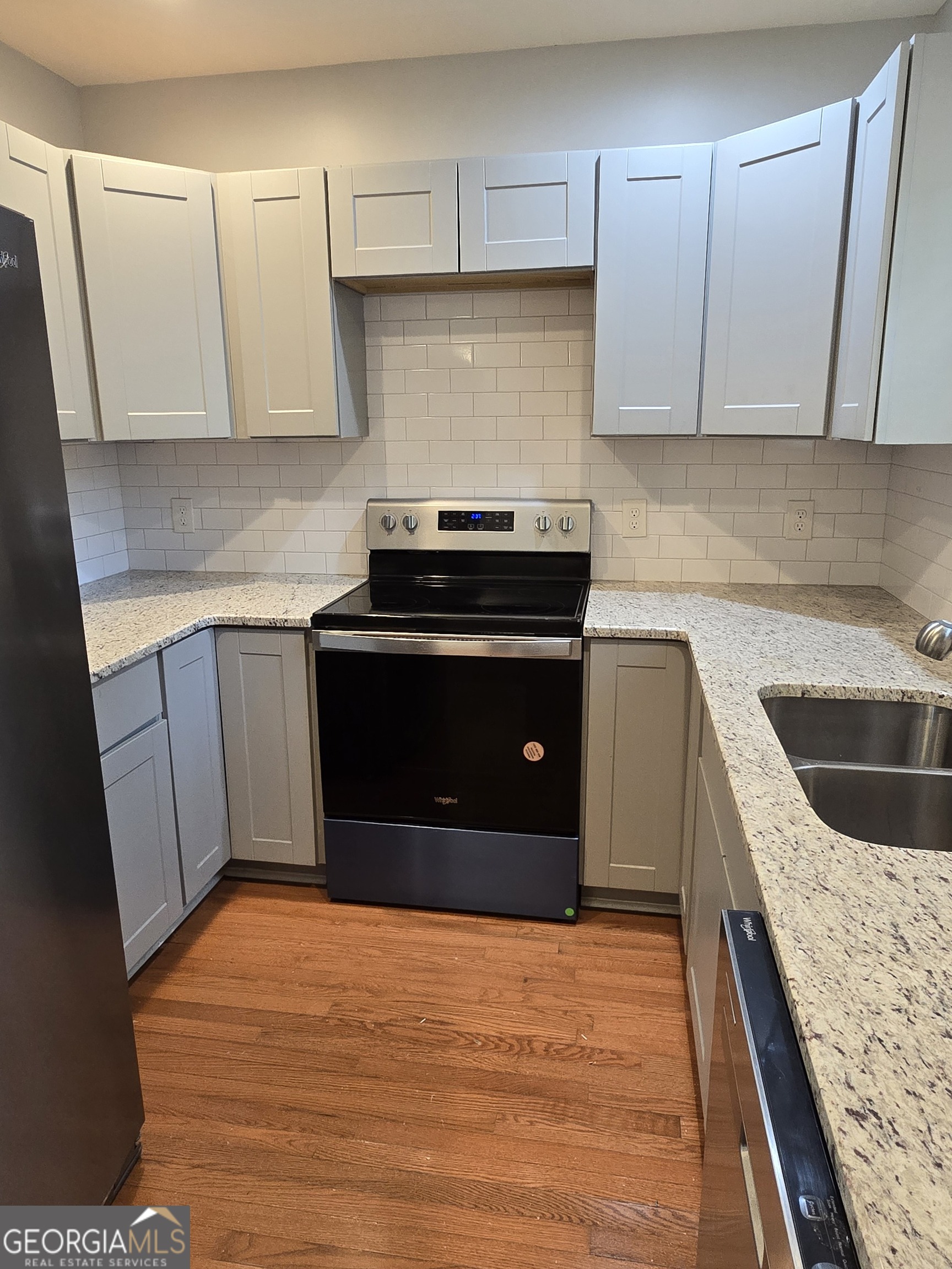 4075 Fairburn Avenue Southwest Atlanta, GA 30331 - Photo 5 of 12 a kitchen with stainless steel appliances granite countertop a stove a sink and a white cabinets