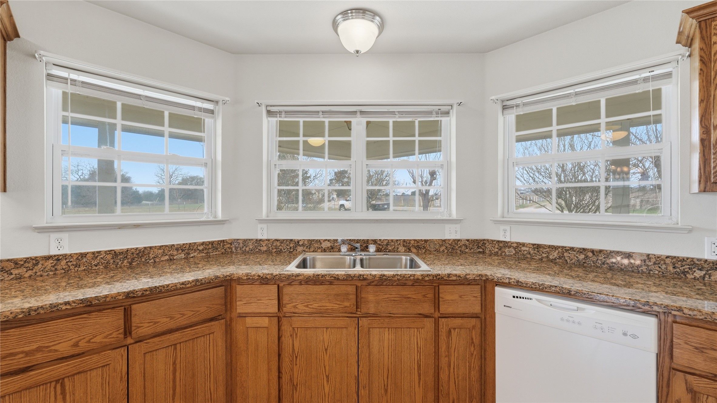 369 Young School House Road Smithville, TX 78957 - Photo 6 of 30 Kitchen featuring wood finish cabinets, dishwasher, and dark stone countertops