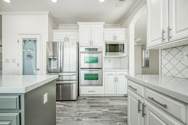 a kitchen with a sink cabinets stainless steel appliances and a window