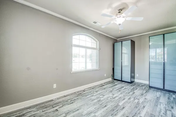 a view of an empty room with window and wooden floor