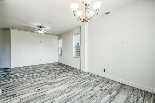 a view of an empty room with wooden floor