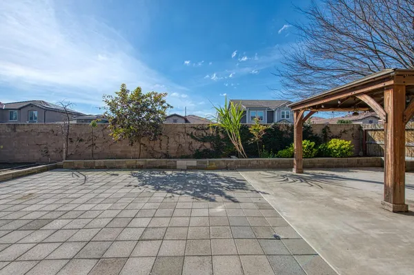 a view of a backyard with table and chairs under an umbrella