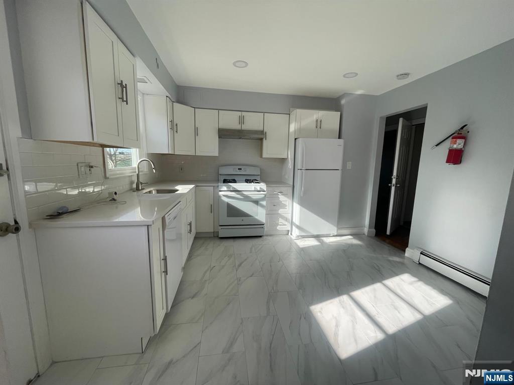 85 Grove Street, Unit 1 South Hackensack, NJ 07606 - Photo 3 of 9 a kitchen with a sink and a refrigerator