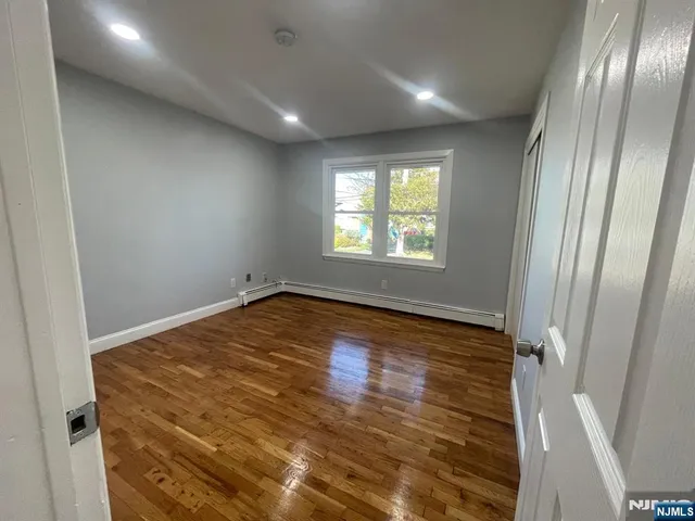 a view of empty room with wooden floor