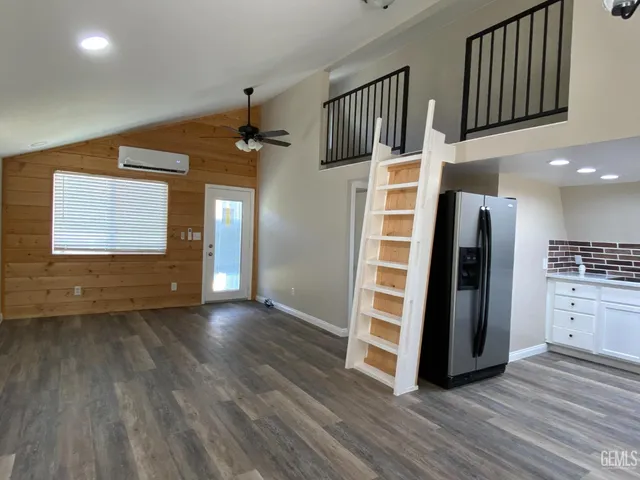 an empty room with wooden floor closet and a ceiling fan