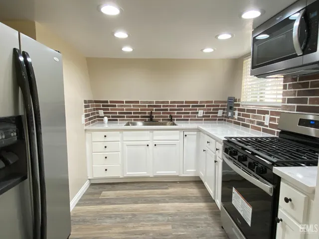 a kitchen with white cabinets and appliances