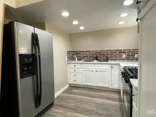 a kitchen with white cabinets and refrigerator