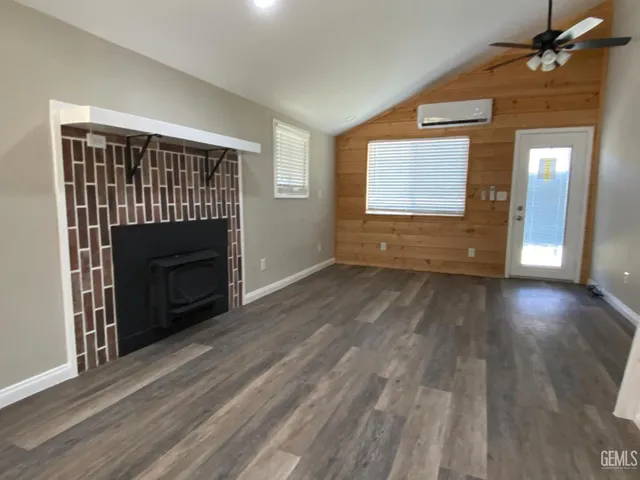 a view of empty room with wooden floor and fireplace