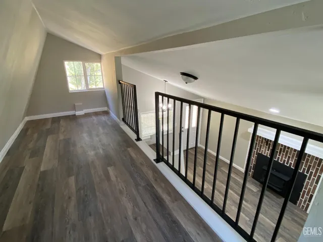 a view of hallway with wooden floor and stairs