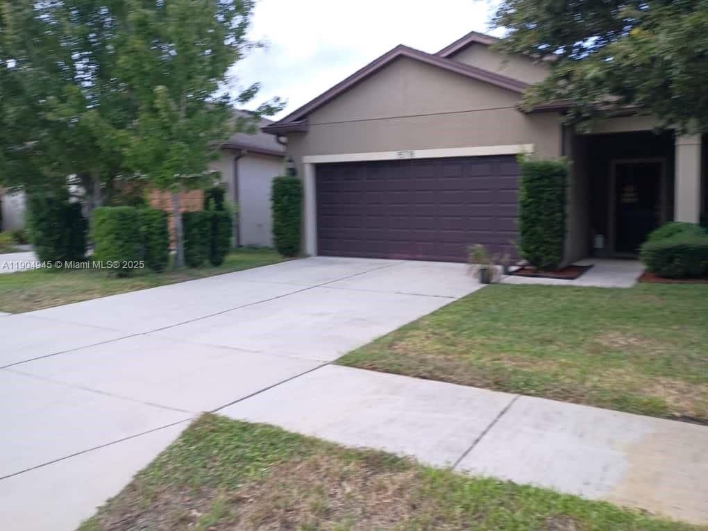 15718 Stone House Drive Spring Hill, FL 34604 - Photo 6 of 10 a front view of a house with a yard and garage