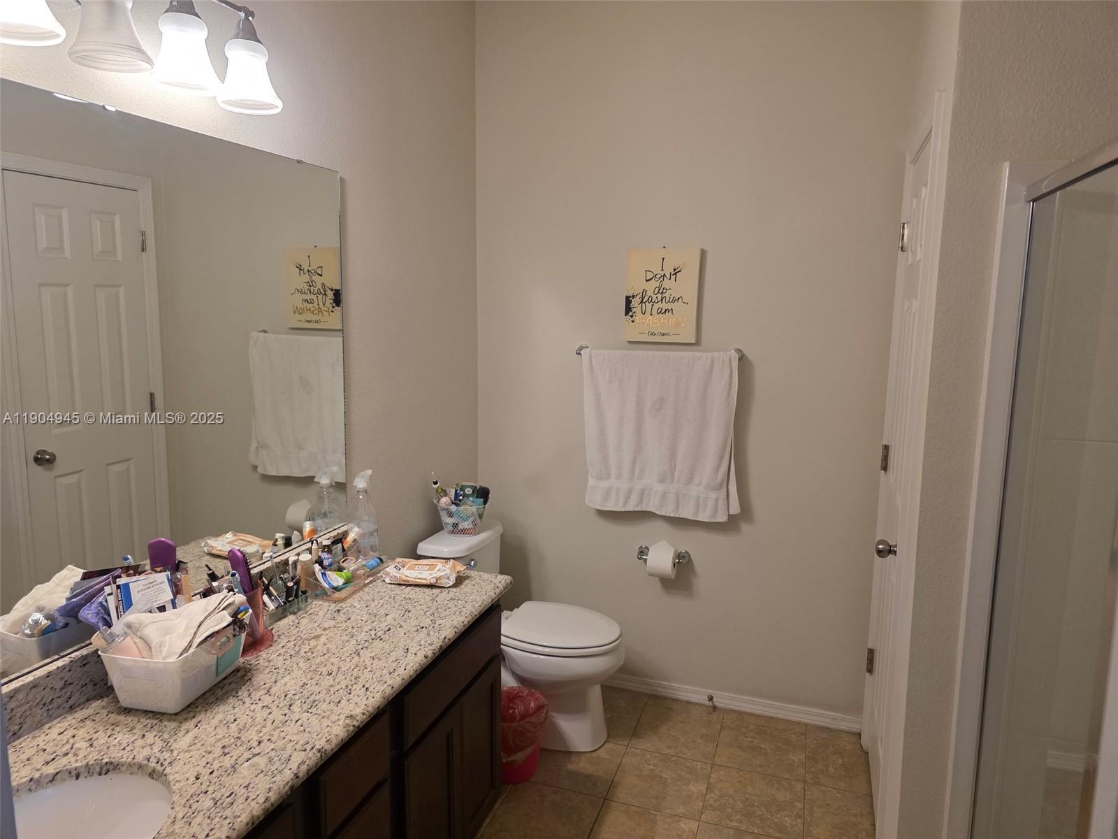 15718 Stone House Drive Spring Hill, FL 34604 - Photo 10 of 10 a bathroom with a granite countertop sink a toilet and a mirror